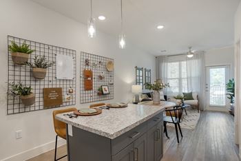 A kitchen with a white counter top and a white wall.
